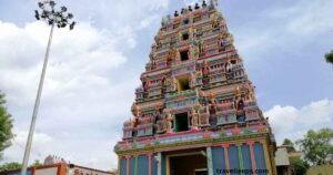 Madapuram Kaali Temple with devotees offering prayers in a serene village setting.